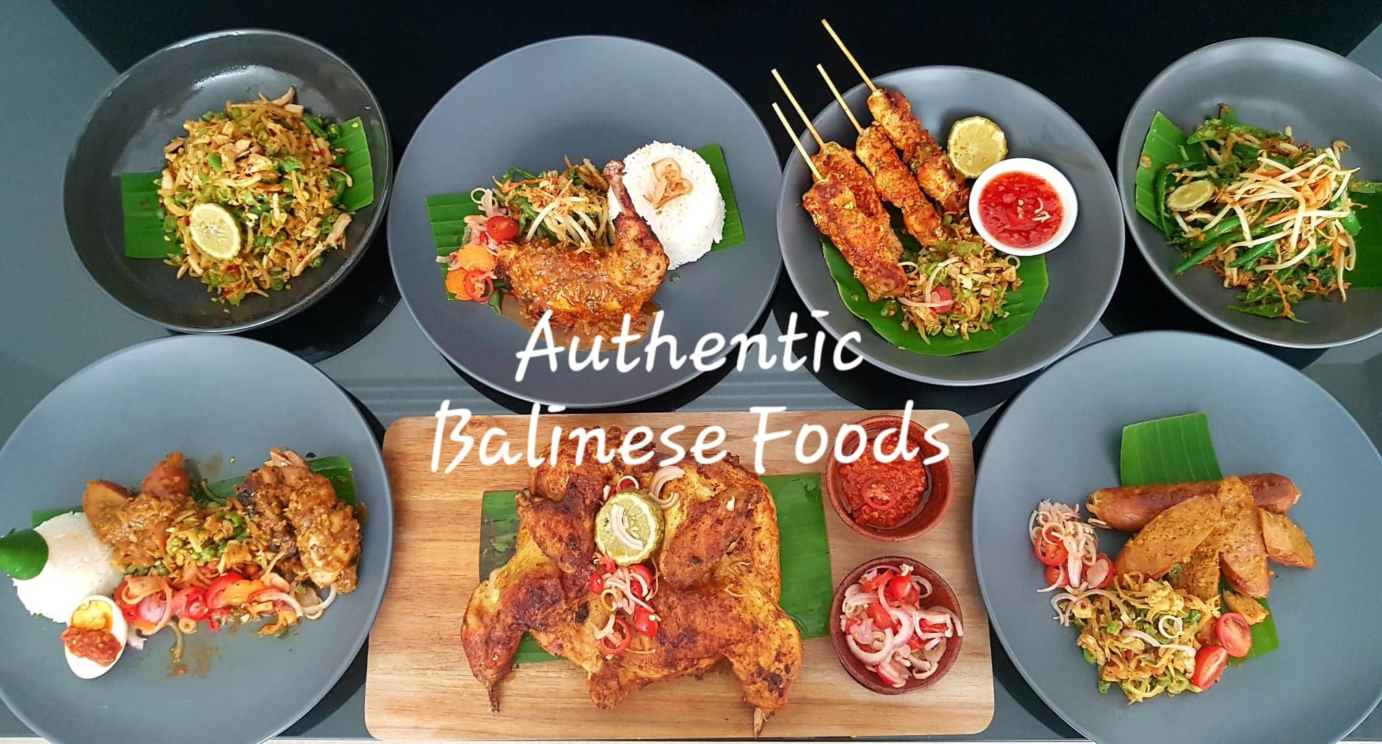 Seven Balinese dishes laid out on banana leaf, including grilled chicken, satay and sambal